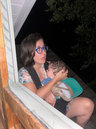 Shabd Simon-Alexander holds his one-year-old daughter on the roof